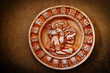 A carved Mayan calendar on textured background