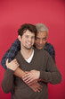 Gay couple hugging on red background