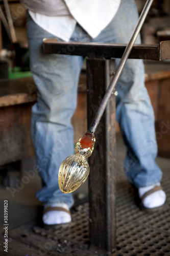 Photo: Glass blower shaping molten glass into a drinking goblet Glass blower shaping molten glass into a drinking goblet