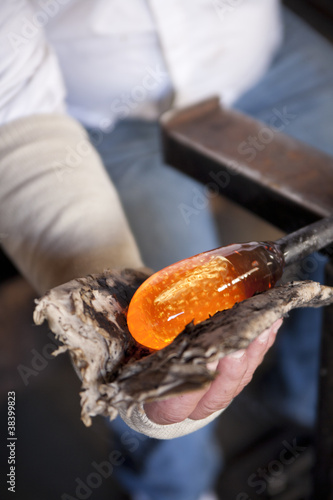 Photo: Glass blower shaping molten glass into a drinking goblet Glass blower shaping molten glass into a drinking goblet