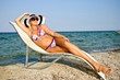 The girl in a hat having a rest on seacoast The girl in a hat having a rest on seacoast
