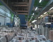 Pile of printed newspapers and workers in printing house.