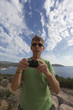 Tourist with Digital Camera in front of Mediterranean Sea