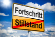 Ortseingangsschild mit Fortschritt und Stillstand