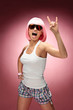 Young girl in pink wig dancing across pink background