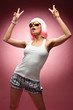 Young girl in pink wig and glasses dancing on a pink background