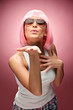 Young girl in pink wig showing something for camera