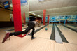 Funny beginner girl playing bowling