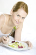 portrait of lying down woman eating salad