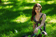 brunette sitting on green grass