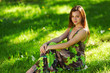 brunette sitting on green grass