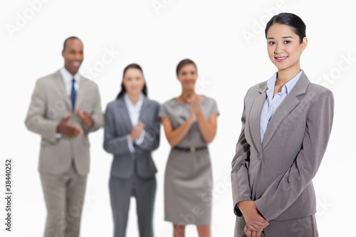 Foto: Businesswoman with co-workers applauding in the background Businesswoman with co-workers applauding in the background