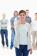 Photo: Close-up of a woman giving the thumb-up with people behind Close-up of a woman giving the thumb-up with people behind