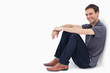 Photo: Close-up of a man smiling while sitting against a wall Close-up of a man smiling while sitting against a wall
