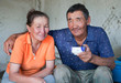A man and a woman of Asian appearance have tea