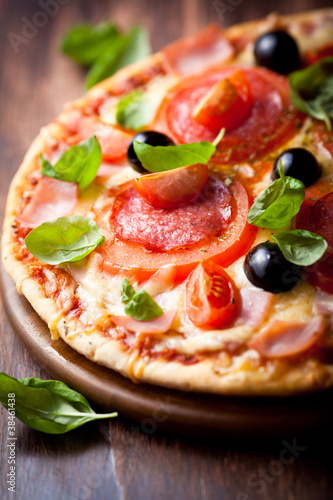 Foto: Pizza with salami, tomatoes and olives Pizza with salami, tomatoes and olives