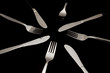 Forks, knives and spoons on a black background