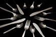 Forks, knives and spoons on a black background