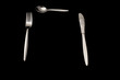 Fork, knife and spoon on a black background