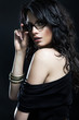 Foto: Portrait of a woman in modern glasses over black isolated backgr Portrait of a woman in modern glasses over black isolated backgr