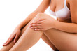 Woman massaging legs sitting on white background