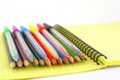 Color pen and pencils on the yellow writing-book Color pen and pencils on the yellow writing-book