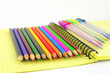 Color pen and pencils on the yellow writing-book Color pen and pencils on the yellow writing-book