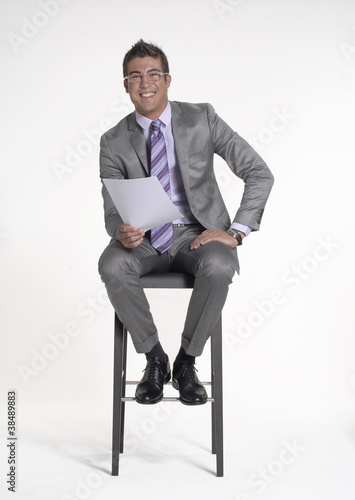 Photo: Joven ejecutivo sentado leyendo. Joven ejecutivo sentado leyendo.
