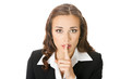 Businesswoman keeping finger on her lips, on white