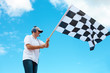 Man waving a checkered flag on a raceway