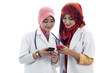 Two young muslim lady doctor share text messaging
