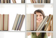 Foto: young Woman looking for a book at the library young Woman looking for a book at the library