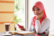 Young muslim stylish women smile while writing text messaging