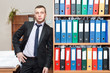 Handsome male business executive standing behind a bookstand