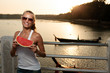 Beautiful woman in sunset light on a pier with watermelon