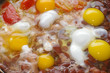 Foto: Raw eggs on boiling sweet brown beans with tomatoes Raw eggs on boiling sweet brown beans with tomatoes