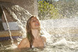 Woman under a spa waterfall