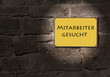Foto: Mitarbeiter gesucht - Gelbes Schild an der Mauer Mitarbeiter gesucht - Gelbes Schild an der Mauer
