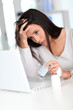 Foto: Woman with headache in front of laptop computer Woman with headache in front of laptop computer