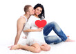 Couple with red heart on the floor, embracing and laughing Couple with red heart on the floor, embracing and laughing