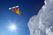 Snowboarder jumping against blue sky