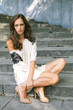 Young beautiful woman woman sits on steps