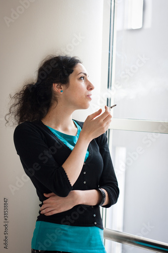 Photo: Young woman smoking indoors Young woman smoking indoors