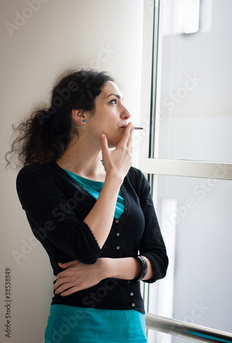 Photo: Young woman smoking indoors Young woman smoking indoors