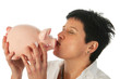 Young woman kissing piggy bank