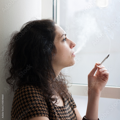 Photo: Young woman smoking indoors Young woman smoking indoors