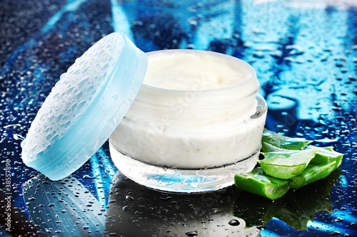 Photo: Opened glass jar of cream and aloe Opened glass jar of cream and aloe