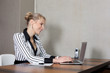 Businessfrau im Hotel mit Laptop am Schreibtisch