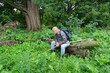 An elderly man with a backpack tourist goes into the thickets