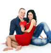 Couple with red heart on the floor, embracing and laughing Couple with red heart on the floor, embracing and laughing